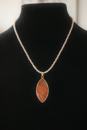 Necklace with a teardrop-shaped pendant on a black stand