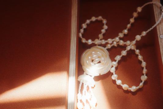 Pearl necklace on a textured surface with soft lighting